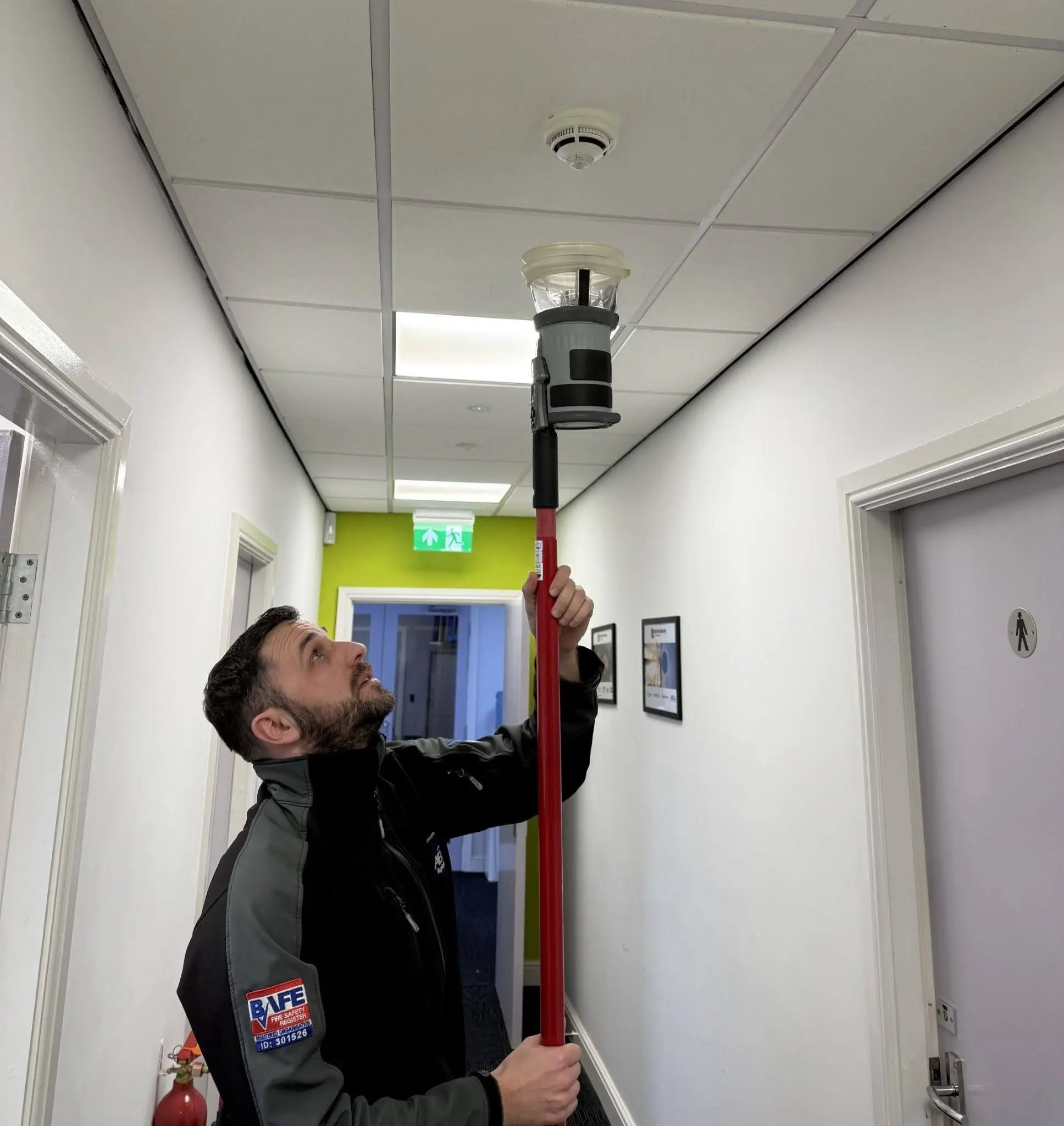 A fire alarm system installed on a concrete wall in a commercial business building.