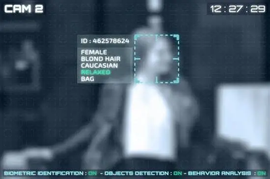 A CCTV camera screen using facial recognition which shows a woman’s face scanned to reveal traits like female, blonde hair and relaxed.